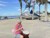 Jane Kerstetter arrives early for a drum circle at Gilchrist Park in Punta Gorda, Florida, on October 12, 2024. A sailboat sits in the backg...