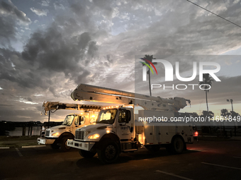 Utility workers supervised by Florida Power and Light work until sunset in Punta Gorda, Florida, on October 12, 2024. Hurricane Milton makes...