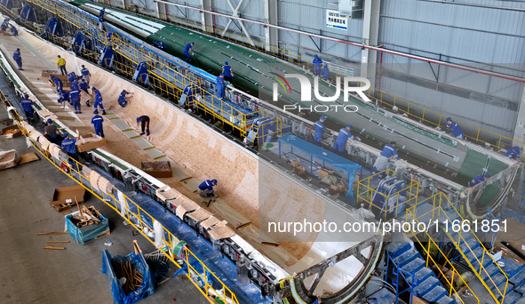 Staff produce wind turbine blades on the Shanghai Electric Wind Power (Zhangye) wind turbine blade production line in Zhangye City, Gansu Pr...