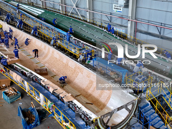 Staff produce wind turbine blades on the Shanghai Electric Wind Power (Zhangye) wind turbine blade production line in Zhangye City, Gansu Pr...