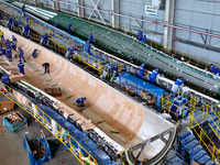 Staff produce wind turbine blades on the Shanghai Electric Wind Power (Zhangye) wind turbine blade production line in Zhangye City, Gansu Pr...