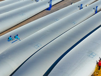 Technicians carry out strict testing of wind turbine blades before they leave the factory in the storage field of the wind turbine blade pro...