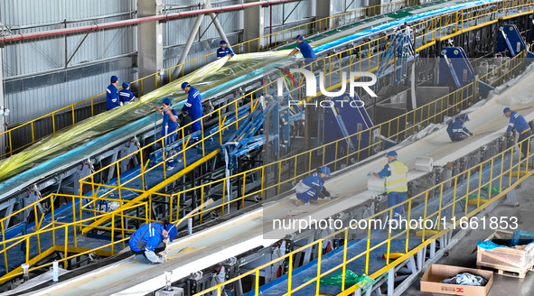 Staff produce wind turbine blades on the Shanghai Electric Wind Power (Zhangye) wind turbine blade production line in Zhangye City, Gansu Pr...