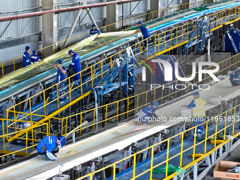 Staff produce wind turbine blades on the Shanghai Electric Wind Power (Zhangye) wind turbine blade production line in Zhangye City, Gansu Pr...