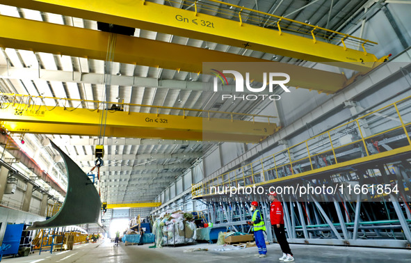 Staff produce wind turbine blades on the Shanghai Electric Wind Power (Zhangye) wind turbine blade production line in Zhangye City, Gansu Pr...