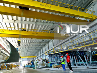 Staff produce wind turbine blades on the Shanghai Electric Wind Power (Zhangye) wind turbine blade production line in Zhangye City, Gansu Pr...