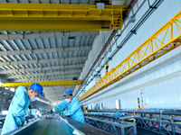 Staff produce wind turbine blades on the Shanghai Electric Wind Power (Zhangye) wind turbine blade production line in Zhangye City, Gansu Pr...