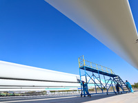 Technicians carry out strict testing of wind turbine blades before they leave the factory in the storage field of the wind turbine blade pro...