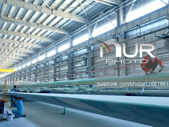 Staff produce wind turbine blades on the Shanghai Electric Wind Power (Zhangye) wind turbine blade production line in Zhangye City, Gansu Pr...