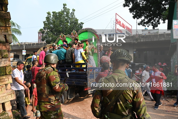 Bangladeshi Army soldiers escort Hindu devotees as they immerse an idol of the Hindu Goddess Durga into the river Buriganga in Dhaka, Bangla...