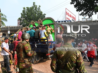 Bangladeshi Army soldiers escort Hindu devotees as they immerse an idol of the Hindu Goddess Durga into the river Buriganga in Dhaka, Bangla...