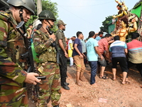 Bangladeshi Army soldiers escort Hindu devotees as they immerse an idol of the Hindu Goddess Durga into the river Buriganga in Dhaka, Bangla...