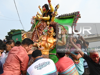 Bangladeshi Hindu devotees immerse an idol of the Hindu Goddess Durga into the river Buriganga in Dhaka, Bangladesh, on October 13, 2024. Th...