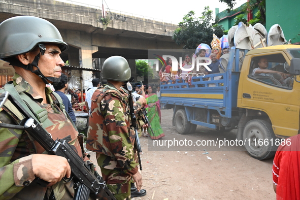 Bangladeshi Army soldiers escort Hindu devotees as they immerse an idol of the Hindu Goddess Durga into the river Buriganga in Dhaka, Bangla...