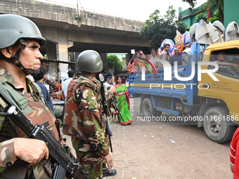 Bangladeshi Army soldiers escort Hindu devotees as they immerse an idol of the Hindu Goddess Durga into the river Buriganga in Dhaka, Bangla...