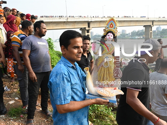 Bangladeshi Hindu devotees immerse an idol of the Hindu Goddess Durga into the river Buriganga in Dhaka, Bangladesh, on October 13, 2024. Th...