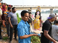 Bangladeshi Hindu devotees immerse an idol of the Hindu Goddess Durga into the river Buriganga in Dhaka, Bangladesh, on October 13, 2024. Th...