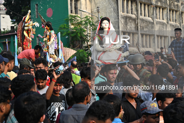 Bangladeshi Hindu devotees immerse an idol of the Hindu Goddess Durga into the river Buriganga in Dhaka, Bangladesh, on October 13, 2024. Th...