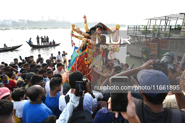 Bangladeshi Hindu devotees immerse an idol of the Hindu Goddess Durga into the river Buriganga in Dhaka, Bangladesh, on October 13, 2024. Th...