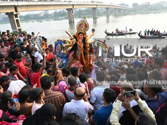 Bangladeshi Hindu devotees immerse an idol of the Hindu Goddess Durga into the river Buriganga in Dhaka, Bangladesh, on October 13, 2024. Th...