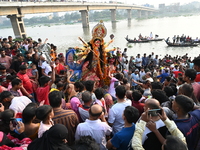 Bangladeshi Hindu devotees immerse an idol of the Hindu Goddess Durga into the river Buriganga in Dhaka, Bangladesh, on October 13, 2024. Th...