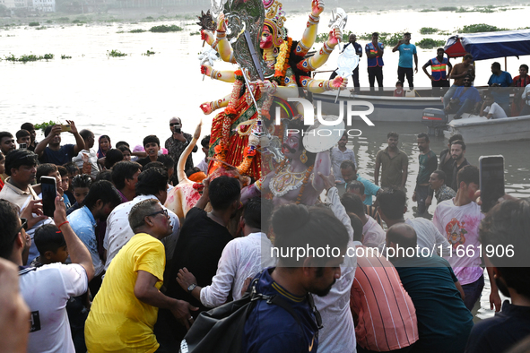 Bangladeshi Hindu devotees immerse an idol of the Hindu Goddess Durga into the river Buriganga in Dhaka, Bangladesh, on October 13, 2024. Th...