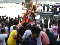 Bangladeshi Hindu devotees immerse an idol of the Hindu Goddess Durga into the river Buriganga in Dhaka, Bangladesh, on October 13, 2024. Th...