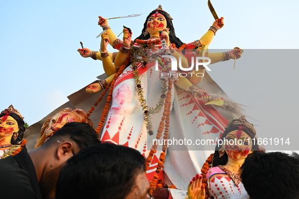 Bangladeshi Hindu devotees immerse an idol of the Hindu Goddess Durga into the river Buriganga in Dhaka, Bangladesh, on October 13, 2024. Th...