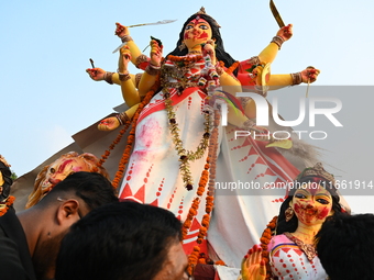 Bangladeshi Hindu devotees immerse an idol of the Hindu Goddess Durga into the river Buriganga in Dhaka, Bangladesh, on October 13, 2024. Th...