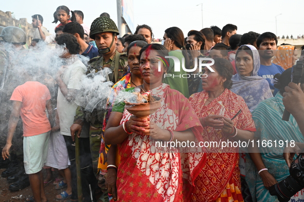 Bangladeshi Hindu devotees immerse an idol of the Hindu Goddess Durga into the river Buriganga in Dhaka, Bangladesh, on October 13, 2024. Th...