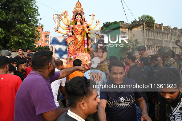 Bangladeshi Hindu devotees immerse an idol of the Hindu Goddess Durga into the river Buriganga in Dhaka, Bangladesh, on October 13, 2024. Th...