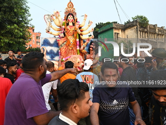 Bangladeshi Hindu devotees immerse an idol of the Hindu Goddess Durga into the river Buriganga in Dhaka, Bangladesh, on October 13, 2024. Th...