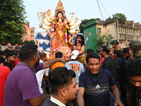 Bangladeshi Hindu devotees immerse an idol of the Hindu Goddess Durga into the river Buriganga in Dhaka, Bangladesh, on October 13, 2024. Th...