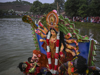 Bangladeshi Hindu devotees immerse an idol of their deity Durga in the pond during the final day (Vijaya Dashami) of the Durga Puja festival...