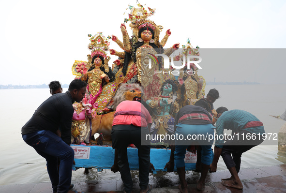 Devotees carry an idol of the Hindu goddess Durga for its immersion into the Hooghly River in Kolkata, India, on October 13, 2024. The annua...