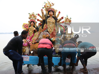 Devotees carry an idol of the Hindu goddess Durga for its immersion into the Hooghly River in Kolkata, India, on October 13, 2024. The annua...