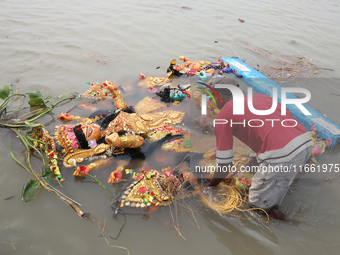 A devotee immerses an idol of the Hindu goddess Durga into the Hooghly River in Kolkata, India, on October 13, 2024. The annual Durga Puja f...