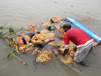 A devotee immerses an idol of the Hindu goddess Durga into the Hooghly River in Kolkata, India, on October 13, 2024. The annual Durga Puja f...