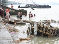 People bathe in the polluted water after the Hindu goddess Durga is immersed in the Hooghly River in Kolkata, India, on October 13, 2024. Th...