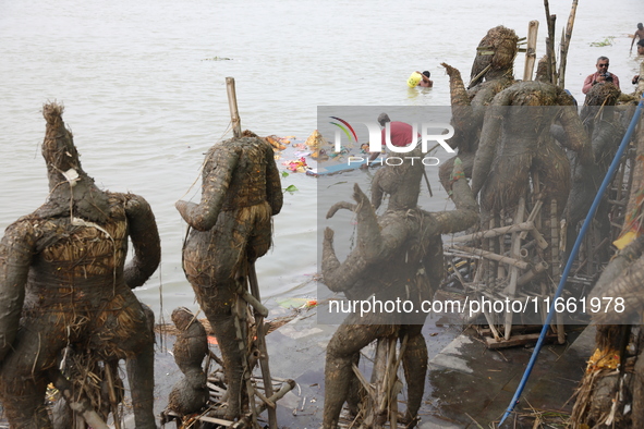 A worker pulls an idol of the Hindu goddess Durga to protect the river water from pollution after it is immersed in the Hooghly River in Kol...