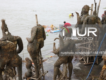 A worker pulls an idol of the Hindu goddess Durga to protect the river water from pollution after it is immersed in the Hooghly River in Kol...