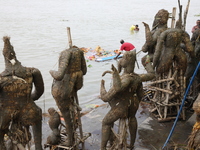 A worker pulls an idol of the Hindu goddess Durga to protect the river water from pollution after it is immersed in the Hooghly River in Kol...