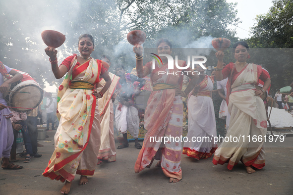 Devotees dance before immersing an idol of the Hindu goddess Durga into the Hooghly River in Kolkata, India, on October 13, 2024. The annual...