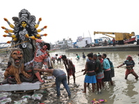 Devotees prepare an idol of the Hindu goddess Durga for its immersion into the Hooghly River in Kolkata, India, on October 13, 2024. The ann...