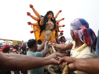 Devotees prepare an idol of the Hindu goddess Durga for its immersion into the Hooghly River in Kolkata, India, on October 13, 2024. The ann...