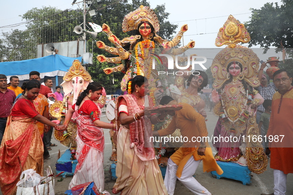 Devotees offer prayers before immersing an idol of the Hindu goddess Durga into the Hooghly River in Kolkata, India, on October 13, 2024. Th...