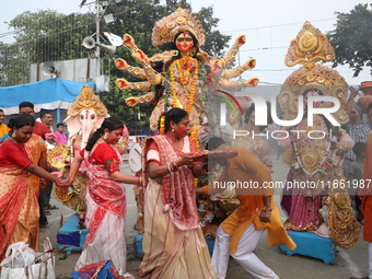 Devotees offer prayers before immersing an idol of the Hindu goddess Durga into the Hooghly River in Kolkata, India, on October 13, 2024. Th...