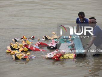 Devotees immerse an idol of the Hindu goddess Durga into the Hooghly River in Kolkata, India, on October 13, 2024. The annual Durga Puja fes...