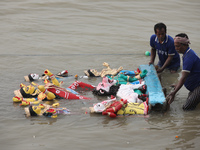 Devotees immerse an idol of the Hindu goddess Durga into the Hooghly River in Kolkata, India, on October 13, 2024. The annual Durga Puja fes...