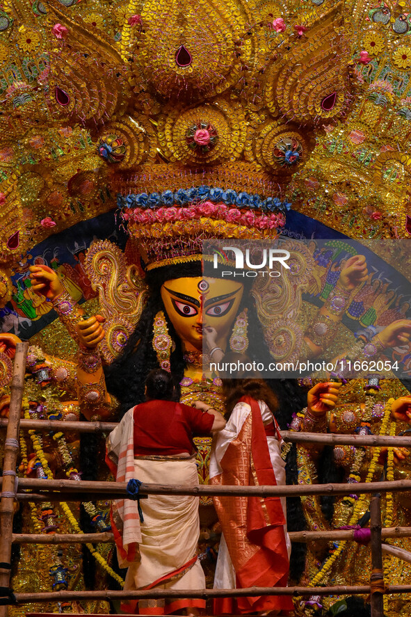 Married women offer their final prayer to Goddess Durga by presenting vermillion and sweets before the immersion of Durga idols on the last...